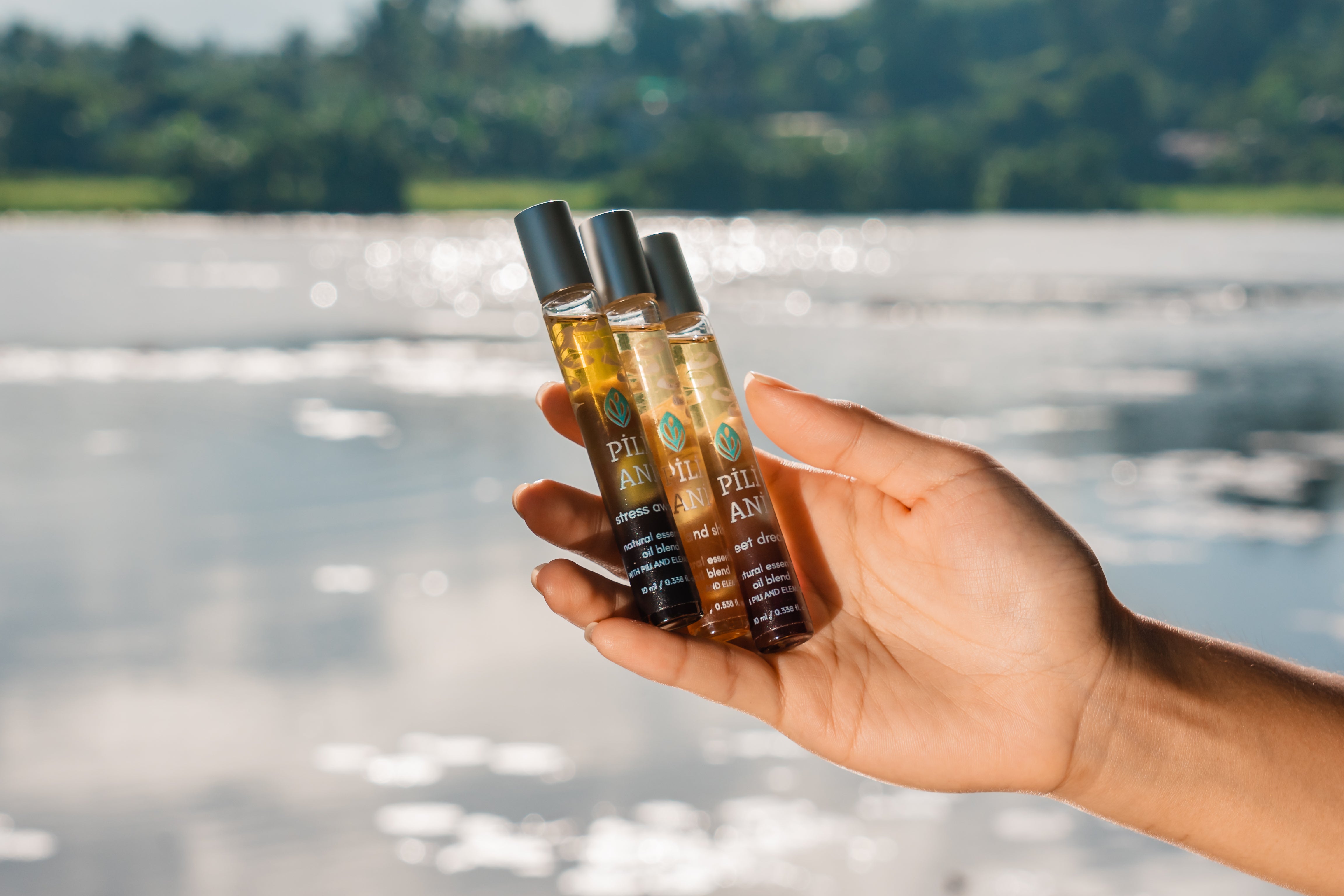 A close-up of Pili Ani’s essential oils held on a person’s hand